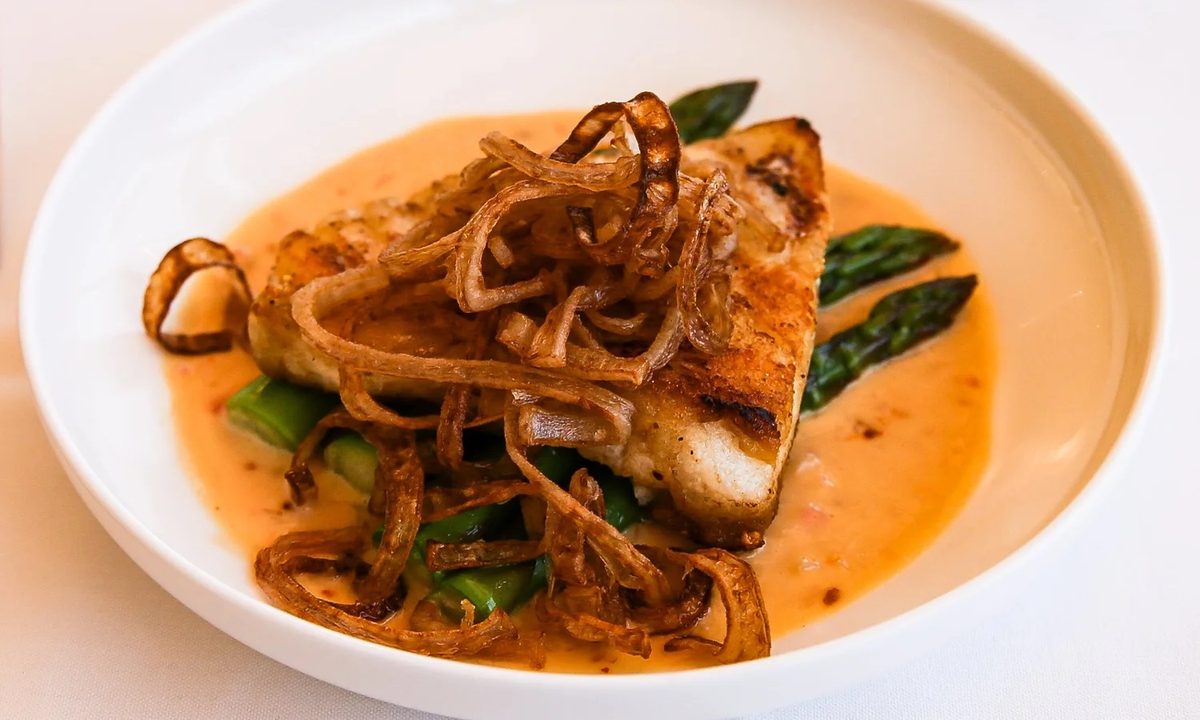 Pan-seared white fish with asparagus, cream sauce and crispy onions from The VUE kitchen
