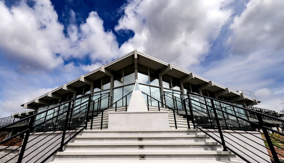 The modern VUE clubhouse and its grand staircase beneath dramatic clouds in Hamden, CT