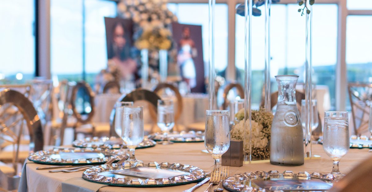 Banquet tables set with gold chargers and centerpieces for a corporate event at The VUE
