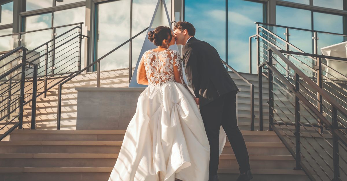 Bride and groom sharing a kiss on the outdoor staircase at The VUE