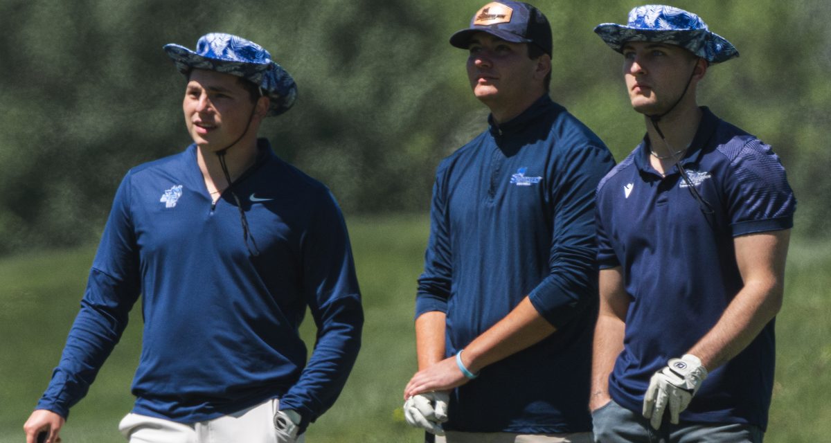 Golfers holding their clubs and watching a shot on the course at The VUE in Hamden, CT