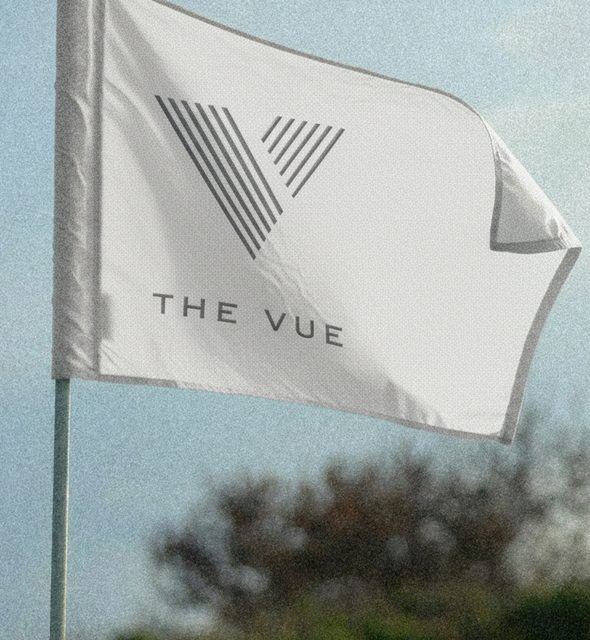 White flag with The VUE logo flying on the golf course