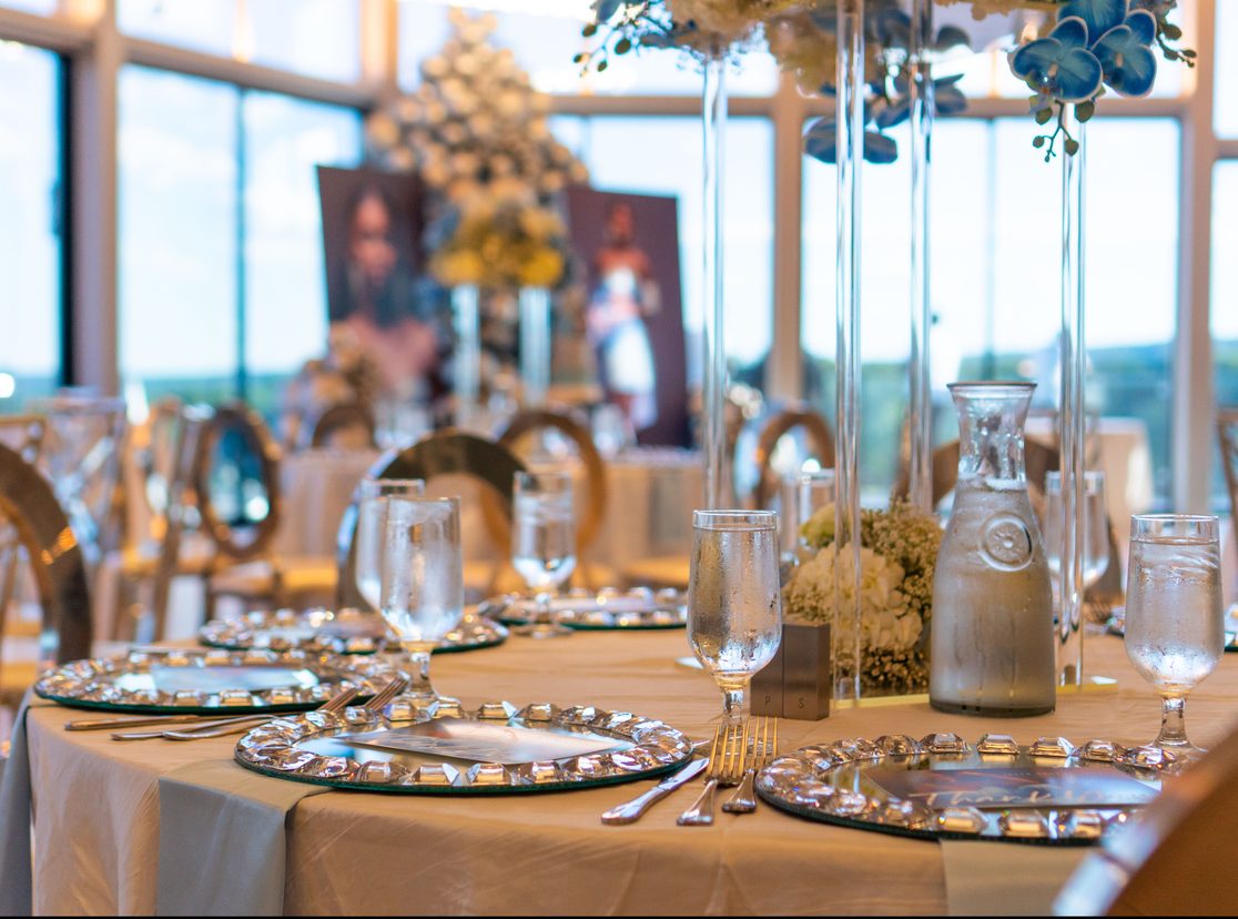 Elegant private event table set with gold chargers, glassware and florals in The VUE ballroom
