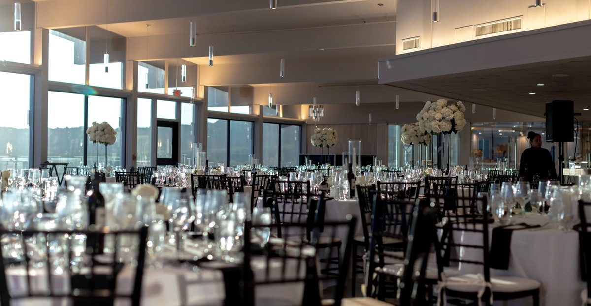The VUE ballroom set for a private party with round tables, glassware and floor-to-ceiling windows